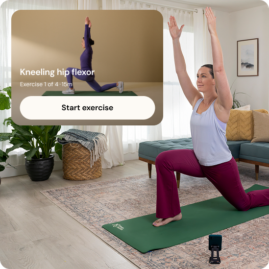 A woman is doing a kneeling stretch on a green yoga mat at home while a closeup of the Hinge Health app is showing the same exercise.