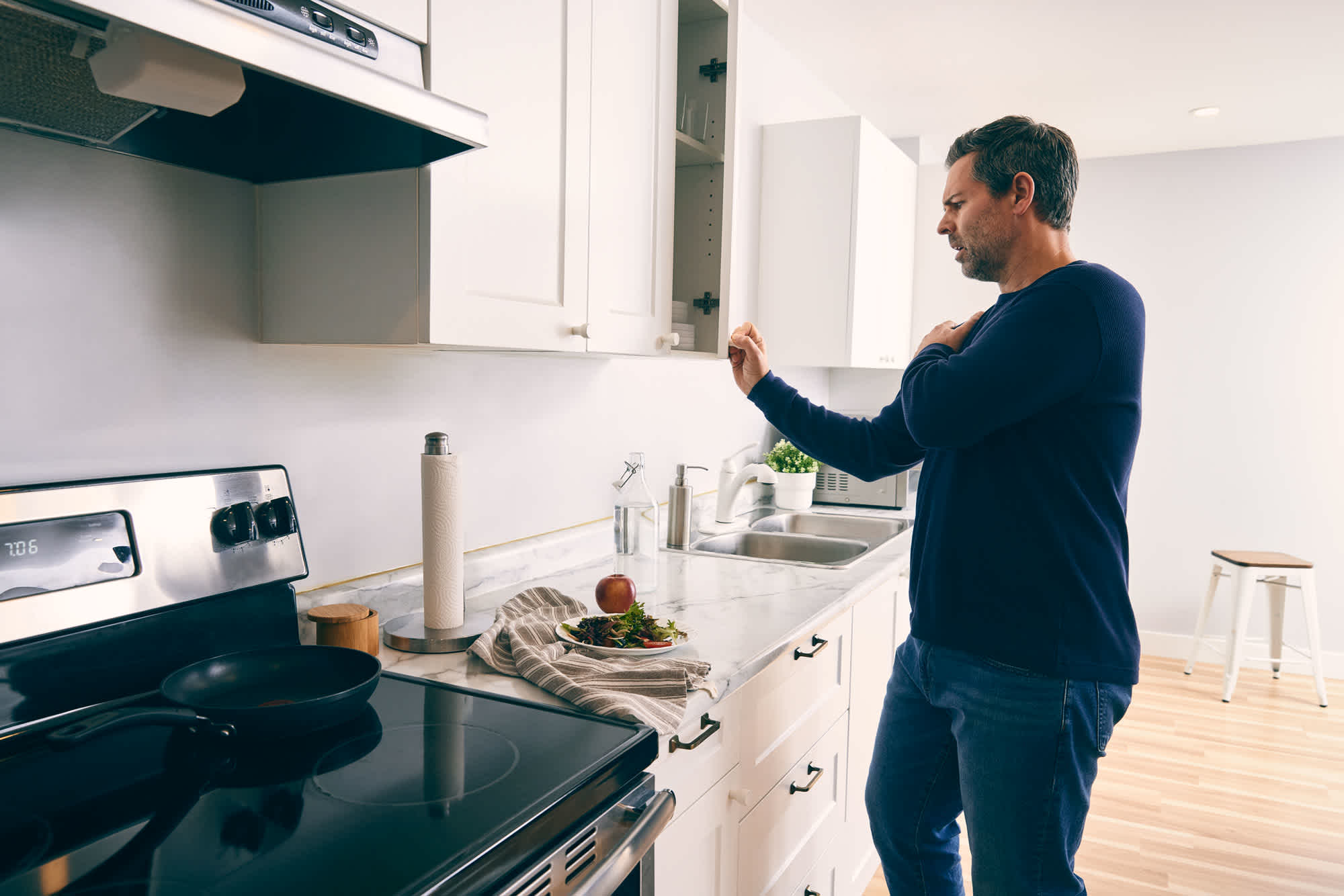 Man-touching-his-shoulder-due-to-muscle-pain-while-cooking