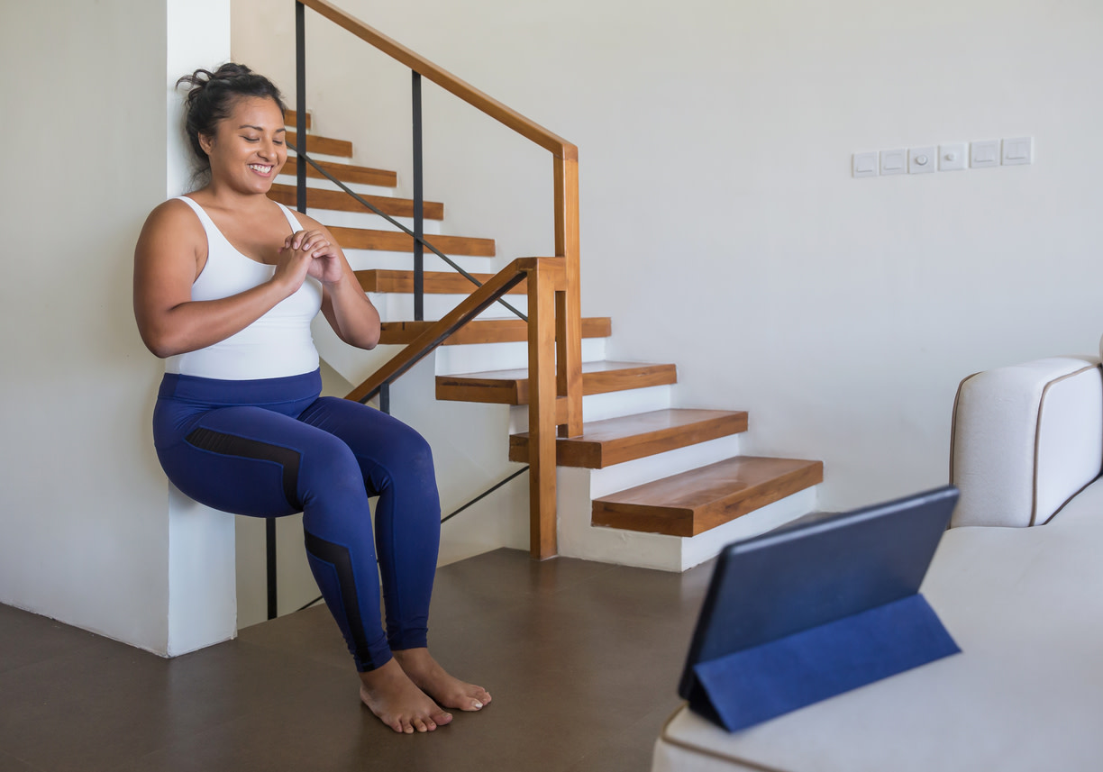 Woman in workout attire practicing ACL rehab exercises.