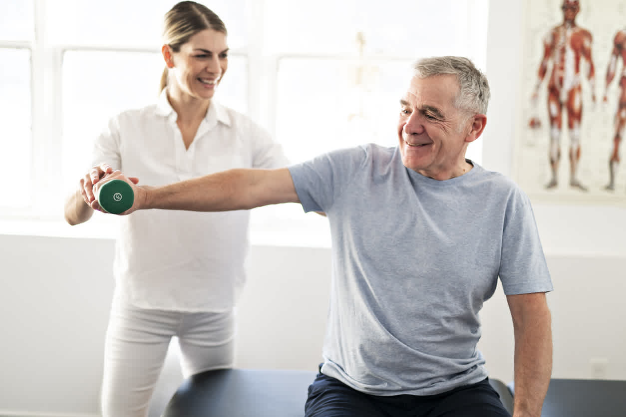 elderly-man-exercising-with-the-help-of-a-woman