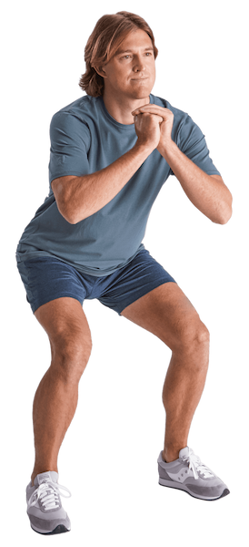 A man in shorts and shirt slightly crouched gripping hands together in front