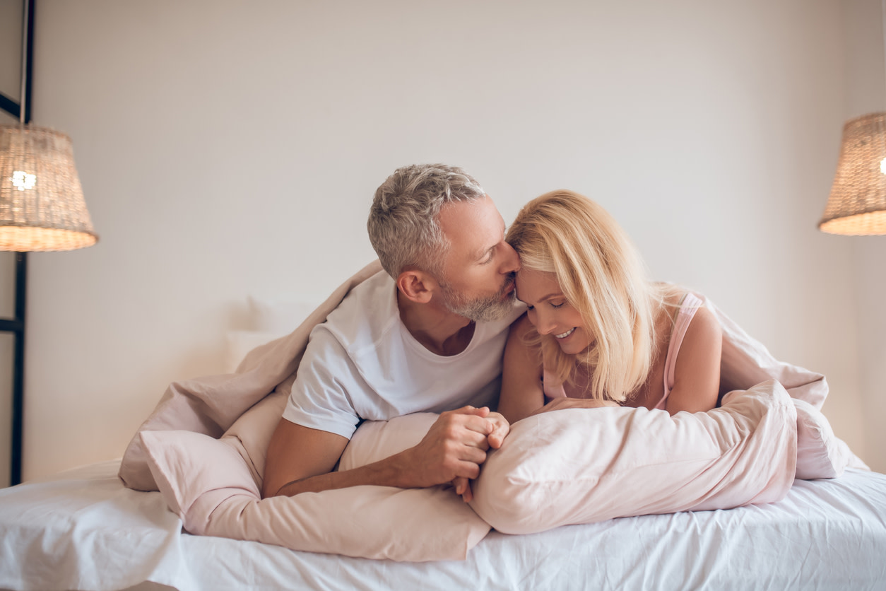 man kissing a woman in the bed