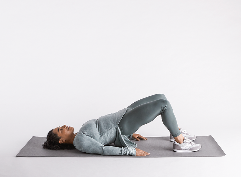 woman-laying-on-her-back-on-yoga-mat-doing-bridges