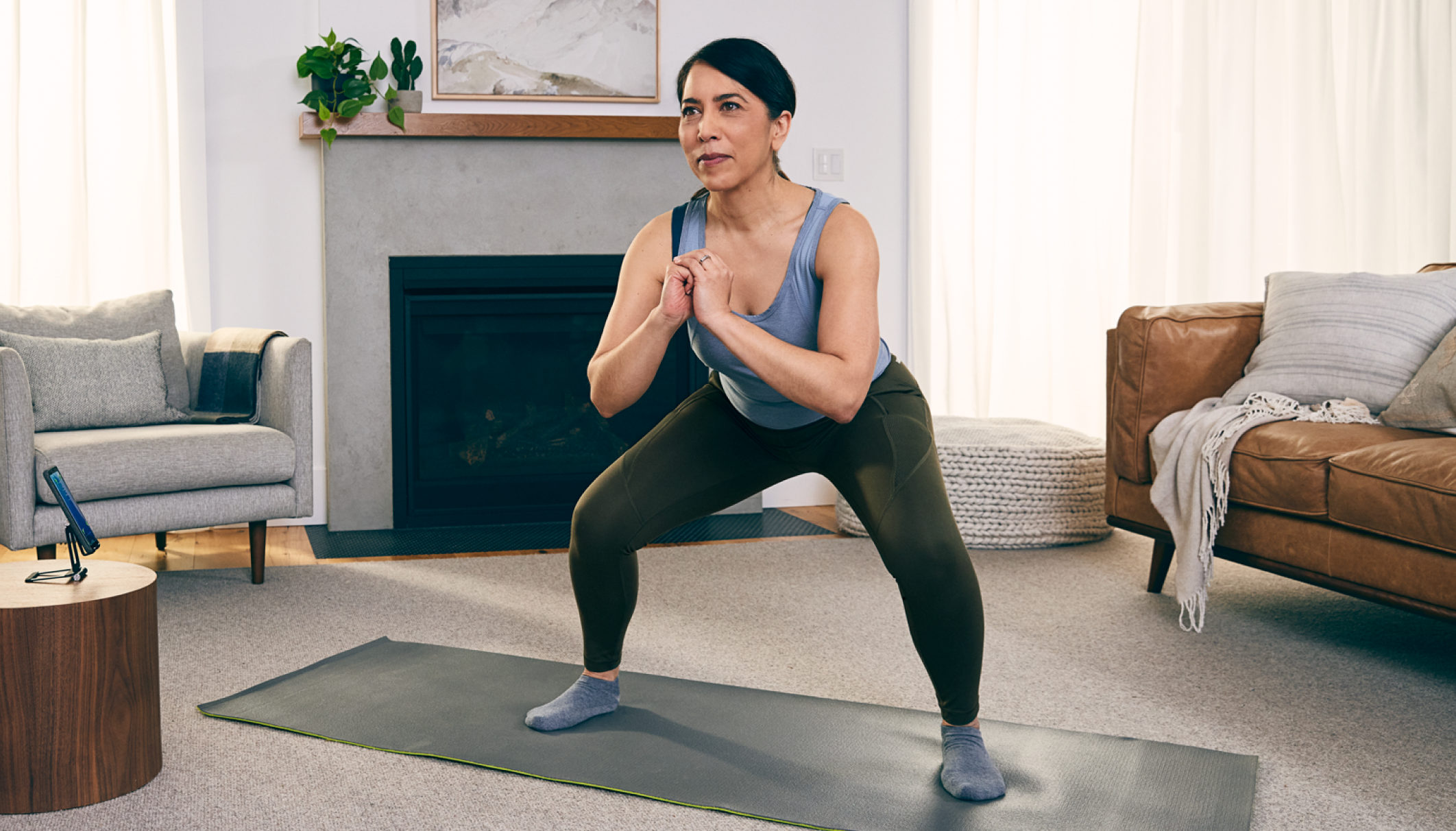Lady in a room doing a yoga pose on a yoga mat