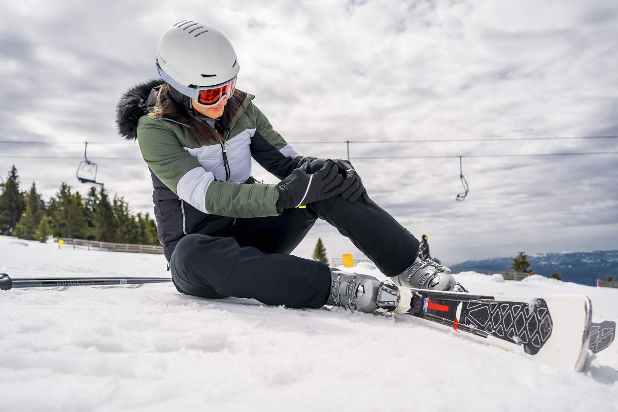 woman feeling knee pain after skiing
