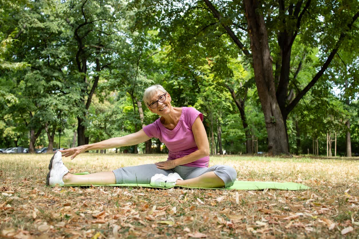 older-woman-stretching-at-park-smiling