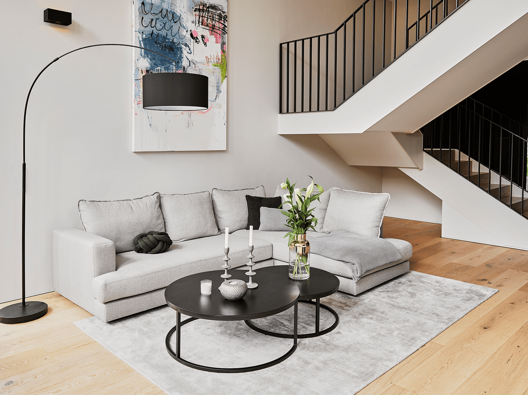 Von Westwing Studio individuell eingerichtetes Wohnzimmer mit grauem Sofa