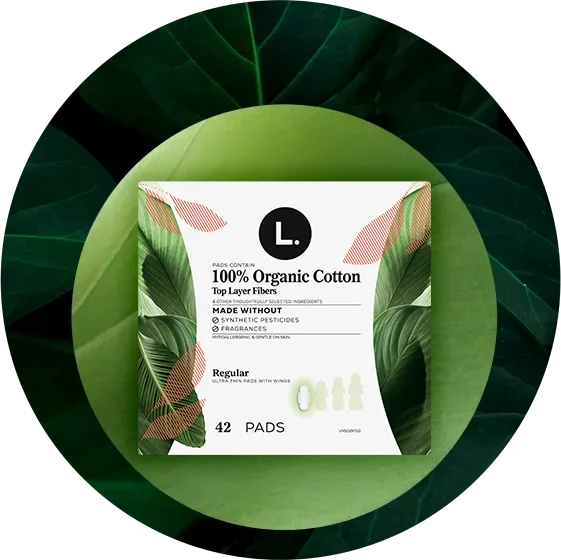 100% Pure Cotton. Organic pads packaging on a leaf-themed background