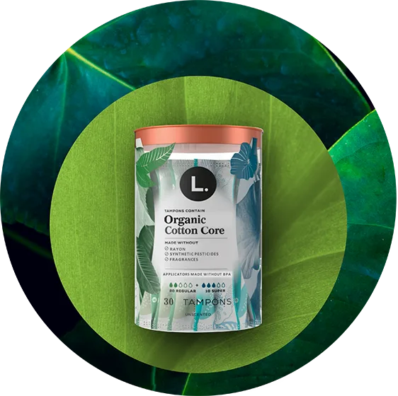 L. Tampons container labeled Organic Cotton Core with text stating made without fragrances, rayon, or synthetic pesticides, and applicator made without BPA.