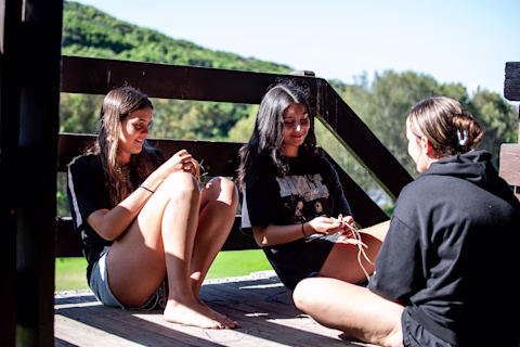 A group of female teens sitting down in the sun A group of female teens sitting down in the sun