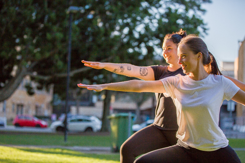 Two women doing yoga in the park