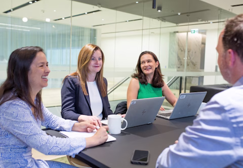 A group of people sitting together with laptops