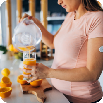 A woman pouring a jug of homemade orange juice