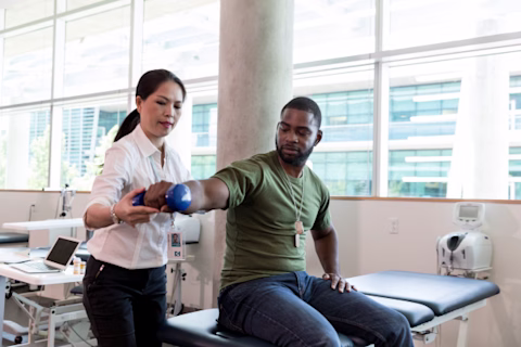 A man lifting a hand-weight with a nurse A man lifting a hand-weight with a nurse