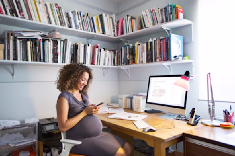 Pregnant lady works from her home office Pregnant lady works from her home office