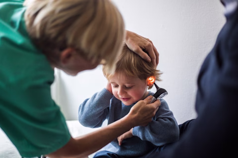 A doctor examining a child's ear A doctor examining a child's ear