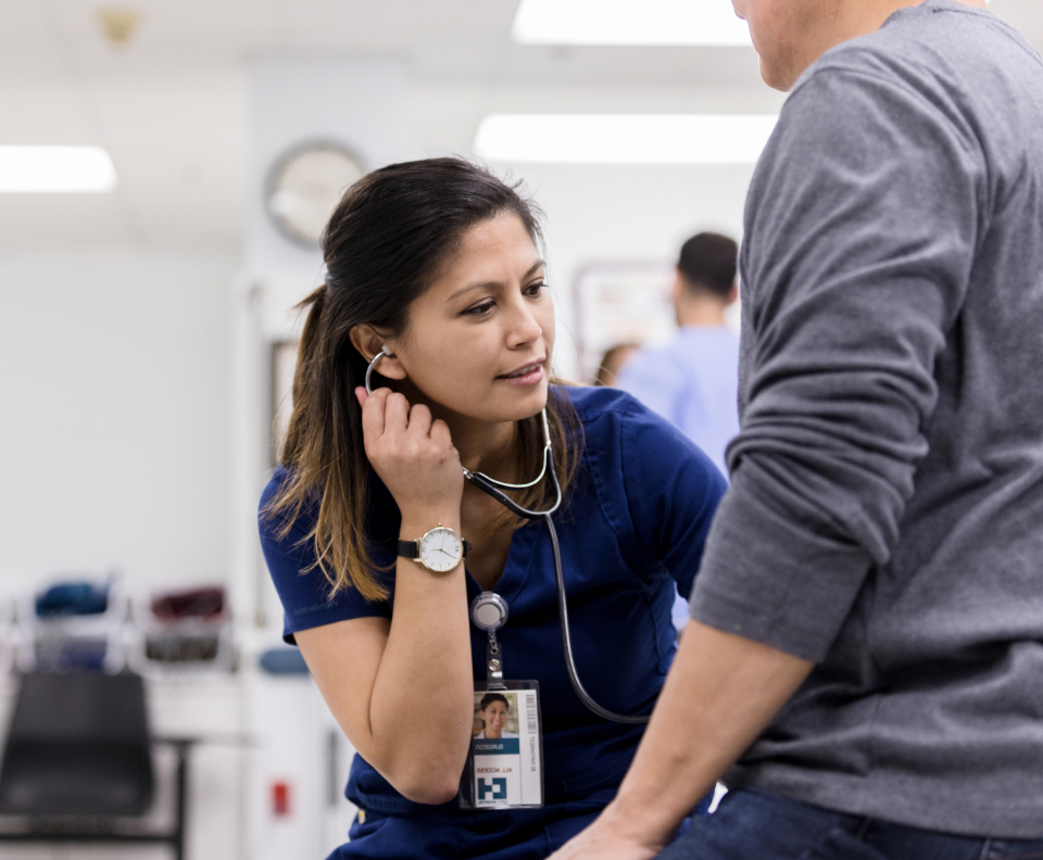 A doctor using a stethoscope on a patient