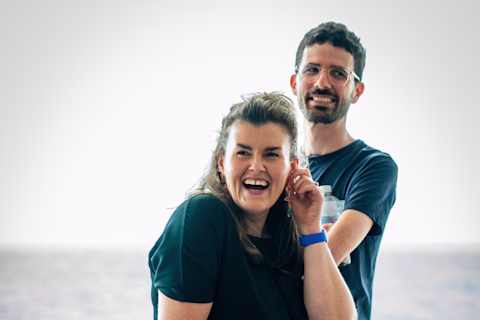 Two people standing next to each other, both are laughing. Two people standing next to each other, both are laughing.