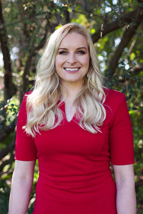 Jess Gallagher elite athlete standing by a tree in a red dress smiling at the camera Jess Gallagher elite athlete standing by a tree in a red dress smiling at the camera