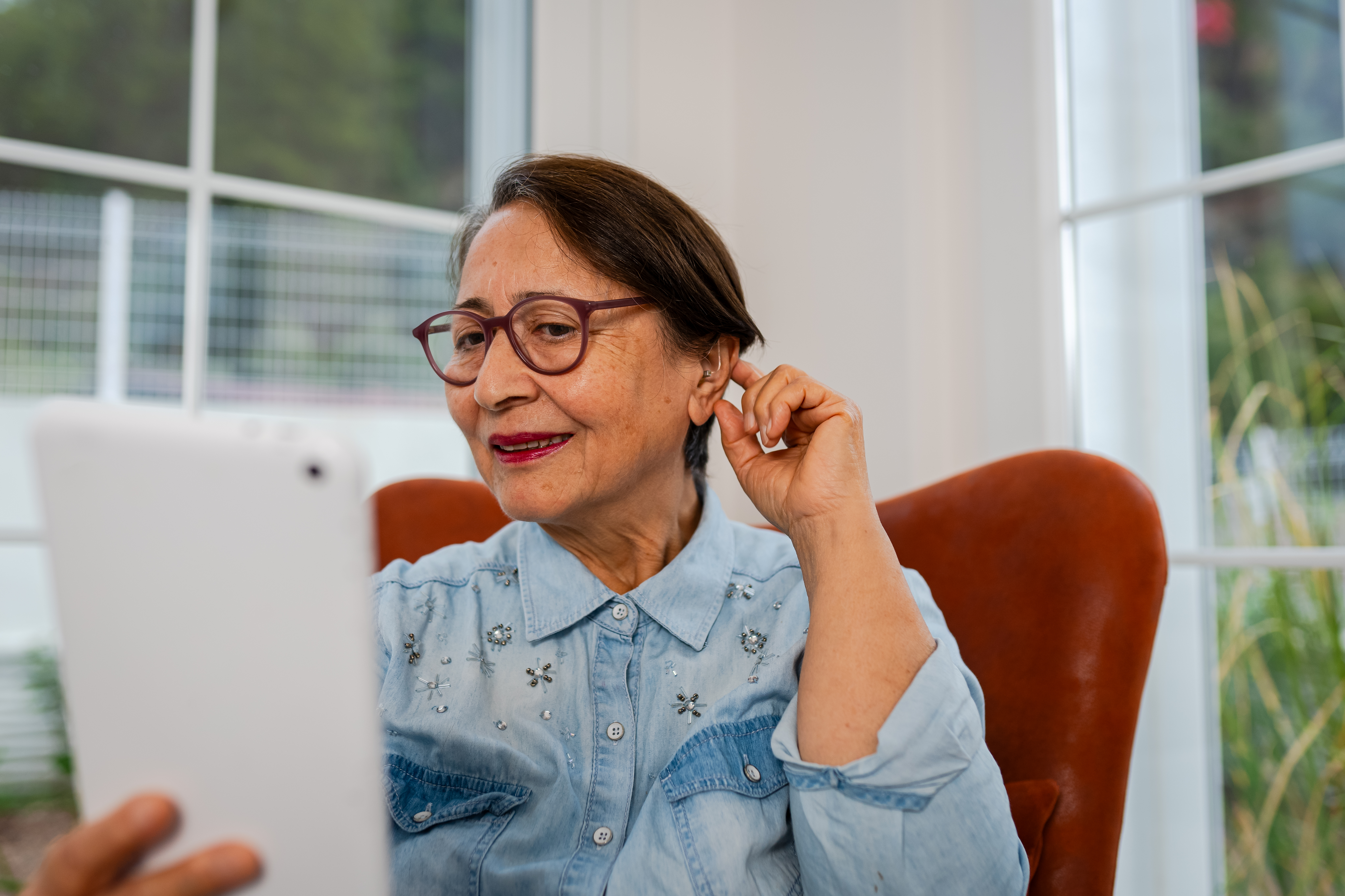 Senior Woman arranging her Hearing Aid