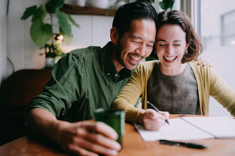 Happy couple planning and designing their future home Happy couple planning and designing their future home