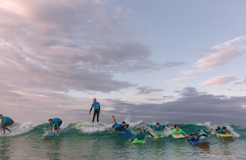 A group of surfers in the ocean at dusk A group of surfers in the ocean at dusk