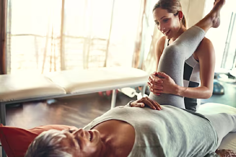 Physiotherapist stretching the leg of a woman. Physiotherapist stretching the leg of a woman.