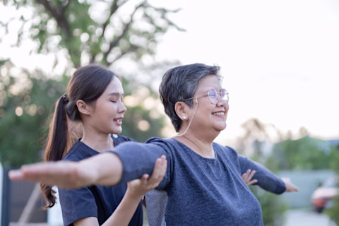 Asian female nurse caregiver exercise with female senior patient Asian female nurse caregiver exercise with female senior patient