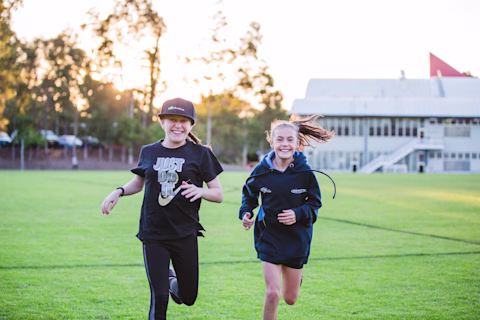 Two young girls running down the field Two young girls running down the field