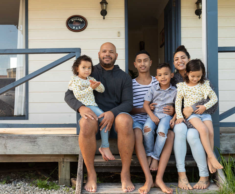 A smiling family sitting on steps