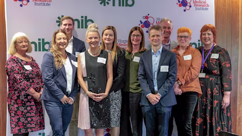 Representatives from HMRI, nib and nib foundation stand smiling in front of a media wall Representatives from HMRI, nib and nib foundation stand smiling in front of a media wall