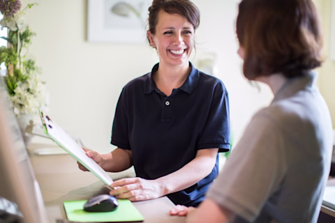 Smiling nurse using digital tablet in employee lounge Smiling nurse using digital tablet in employee lounge