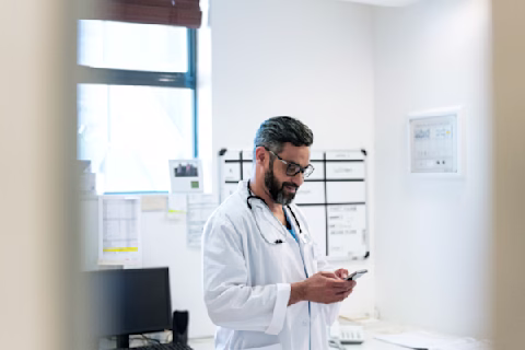 Doctor text messaging using phone in hospital Doctor text messaging using phone in hospital