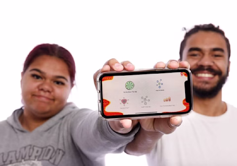 Female and male Indigenous holding out a phone Female and male Indigenous holding out a phone