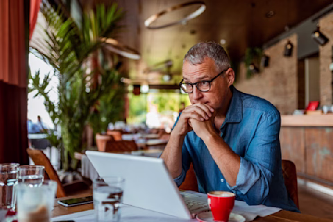 A man wearing glasses using a laptop A man wearing glasses using a laptop