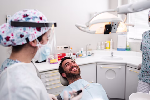 Dentist and assistant talking to the patient before his revision Dentist and assistant talking to the patient before his revision