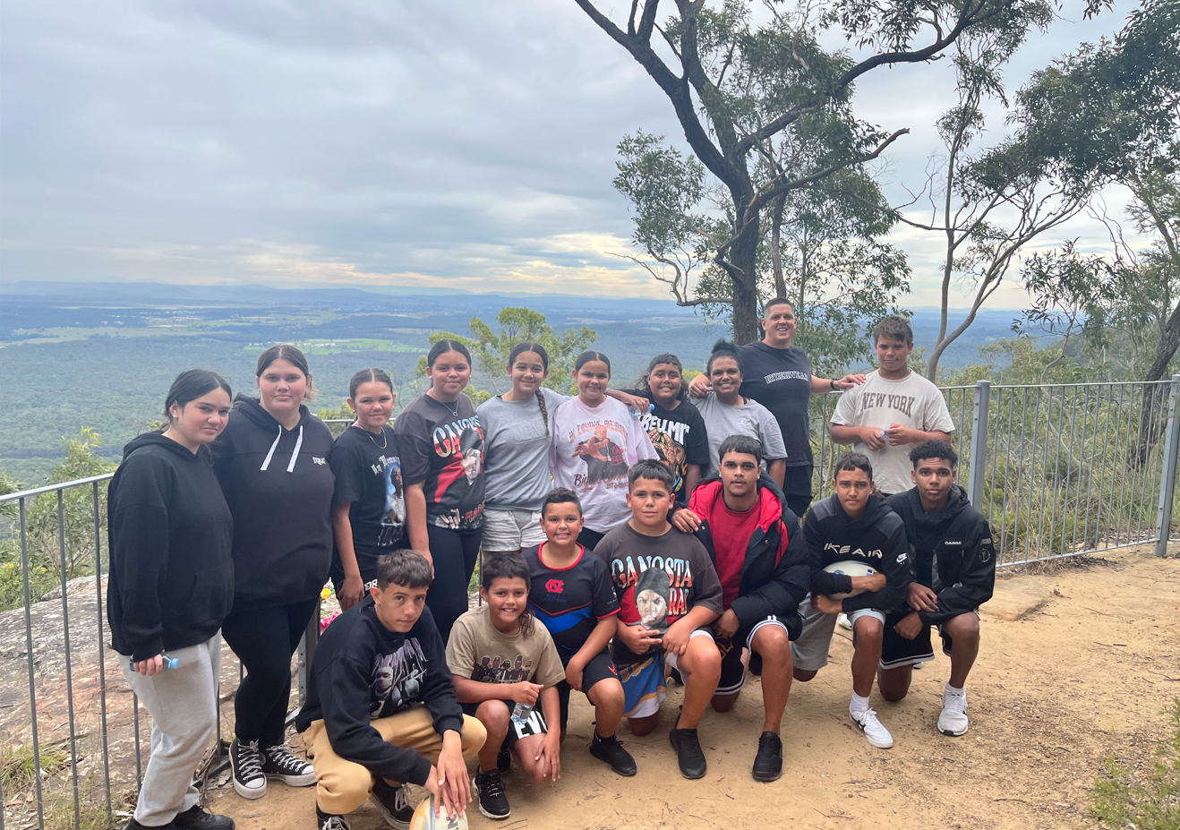 Group of teenagers posing together at a cliff look out spot