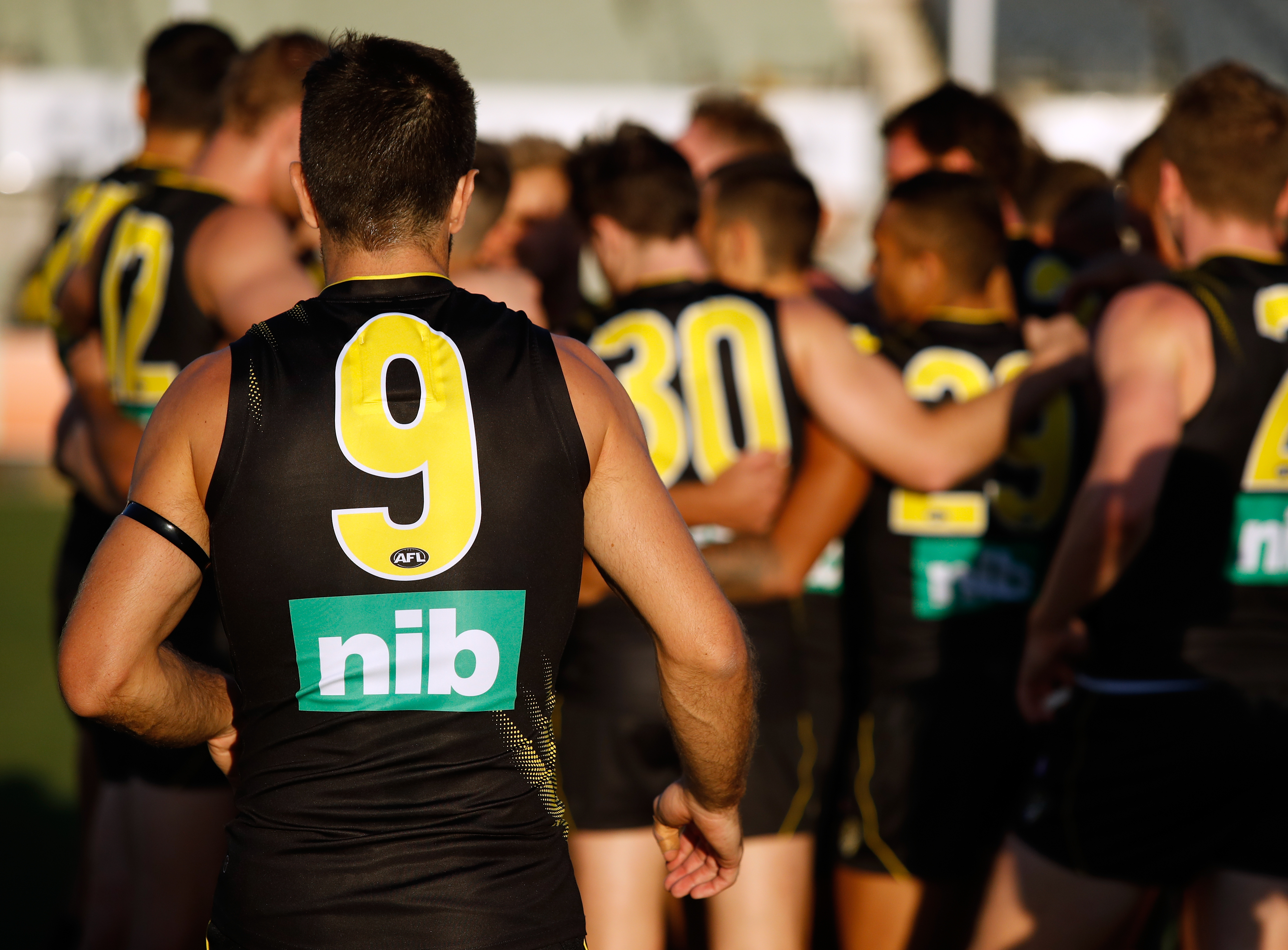 AFL player with #9 on his jersey running to his team