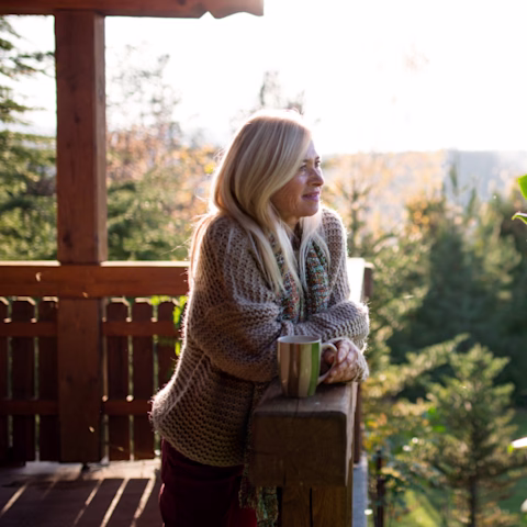 A woman on her balcony enjoying the sunshine A woman on her balcony enjoying the sunshine