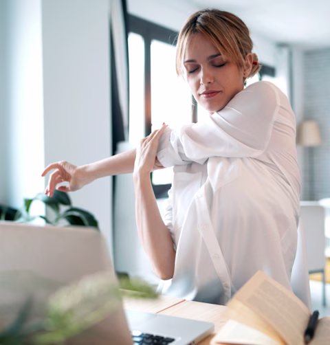 Tired woman stretching while working from home Tired woman stretching while working from home