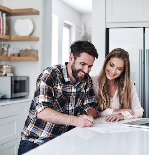 Couple in the kitchen with a laptop and paper documents Couple in the kitchen with a laptop and paper documents