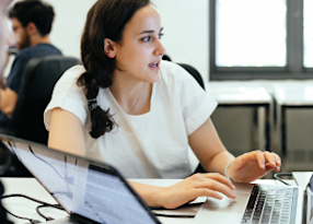 Woman teaching another student how to code
