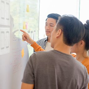 People learning UX/UI design on a whiteboard
