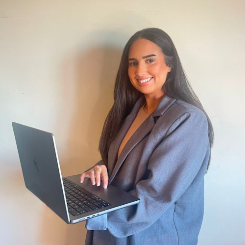 A portrait photo of Naz holding a laptop