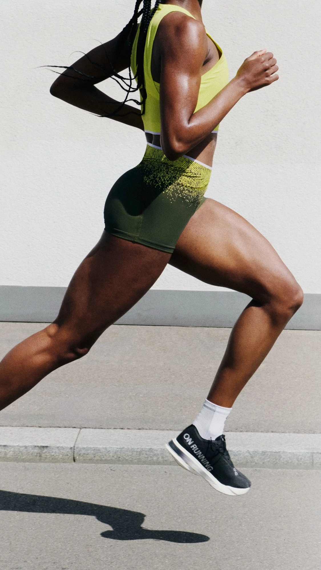 A runner in On gear from the side, mid-stride.