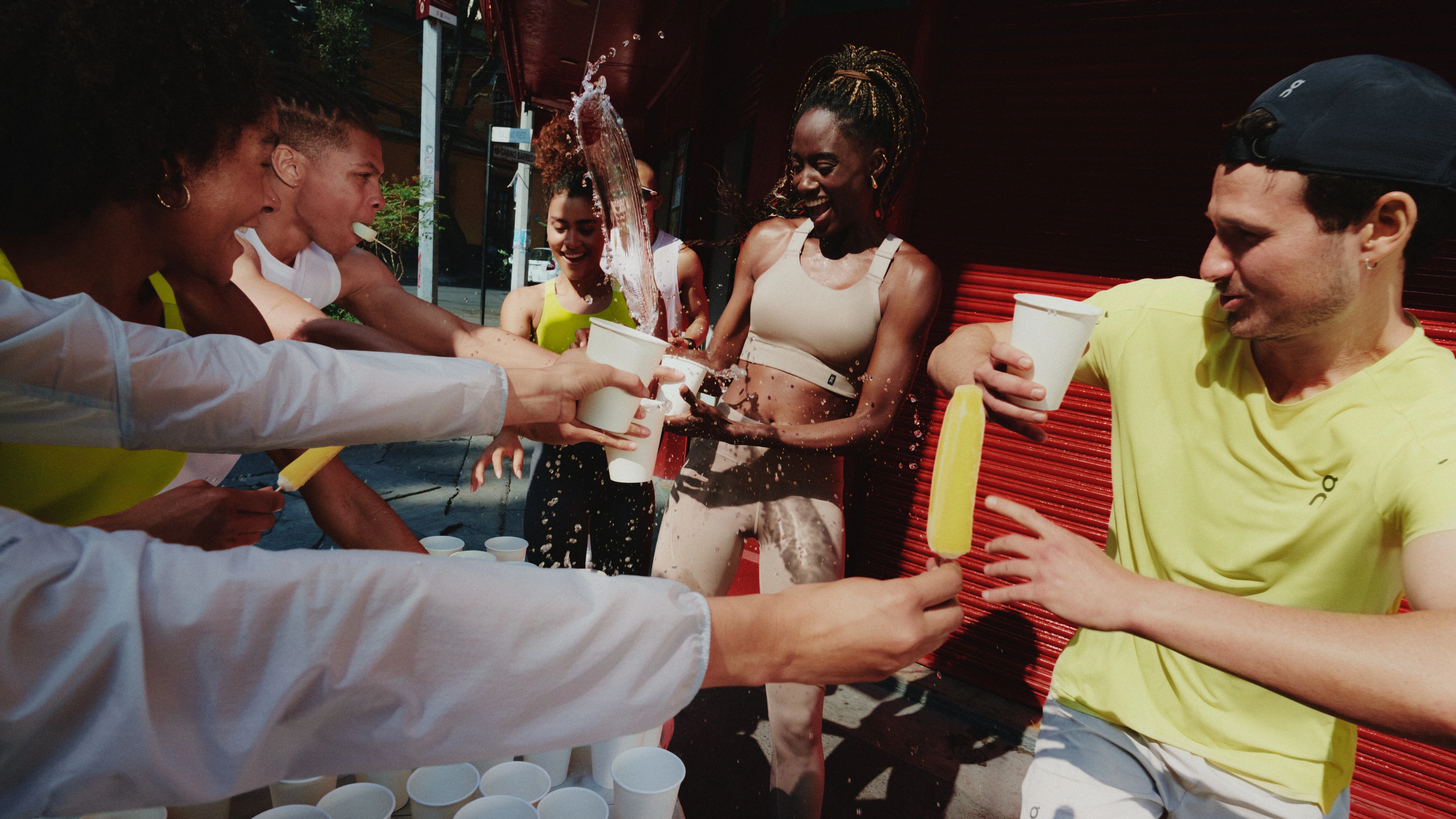 Atleti e atlete si rinfrescano con acqua e ghiaccioli dopo una corsa.