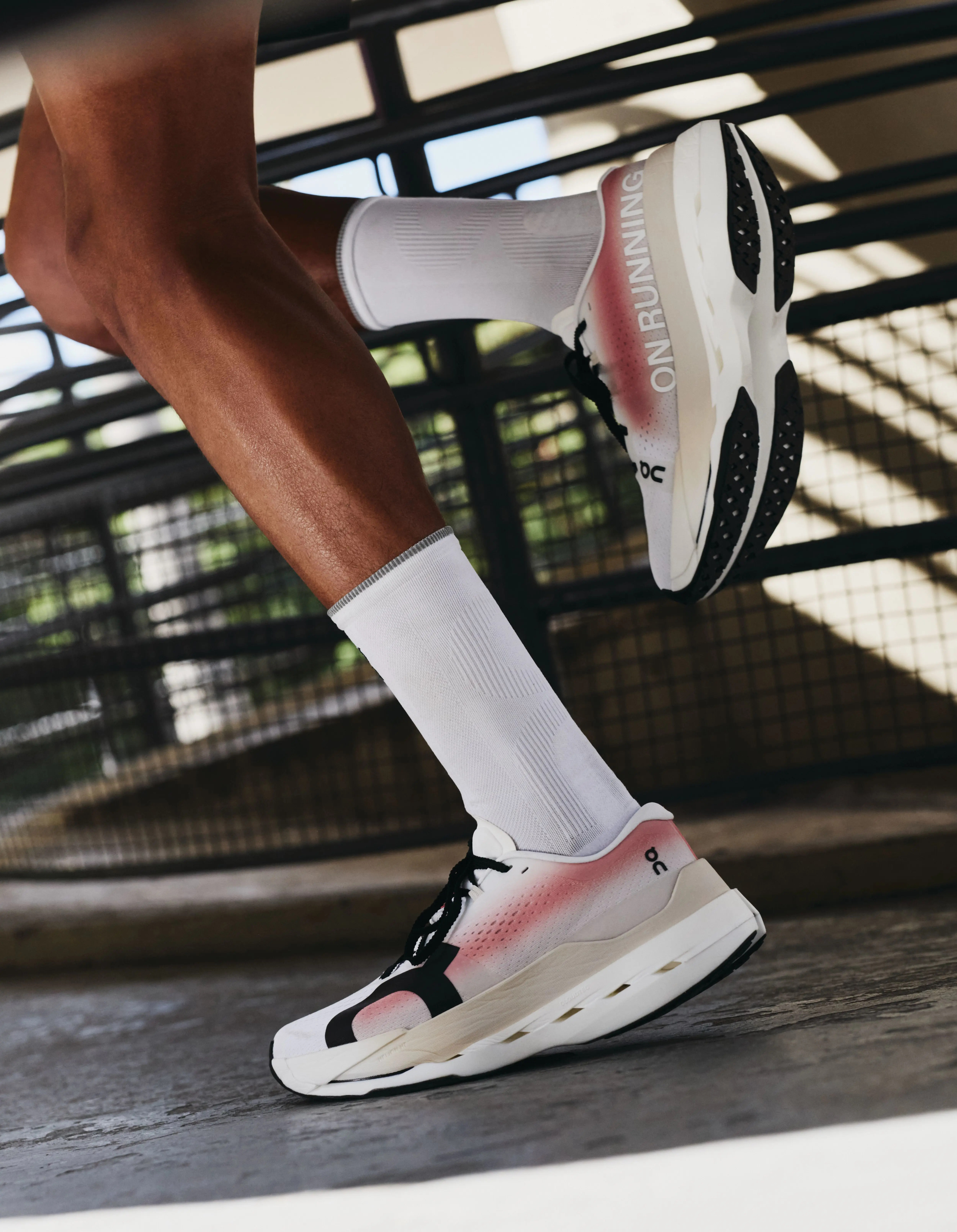 On runners on a runner in mid-stride in a cityscape.