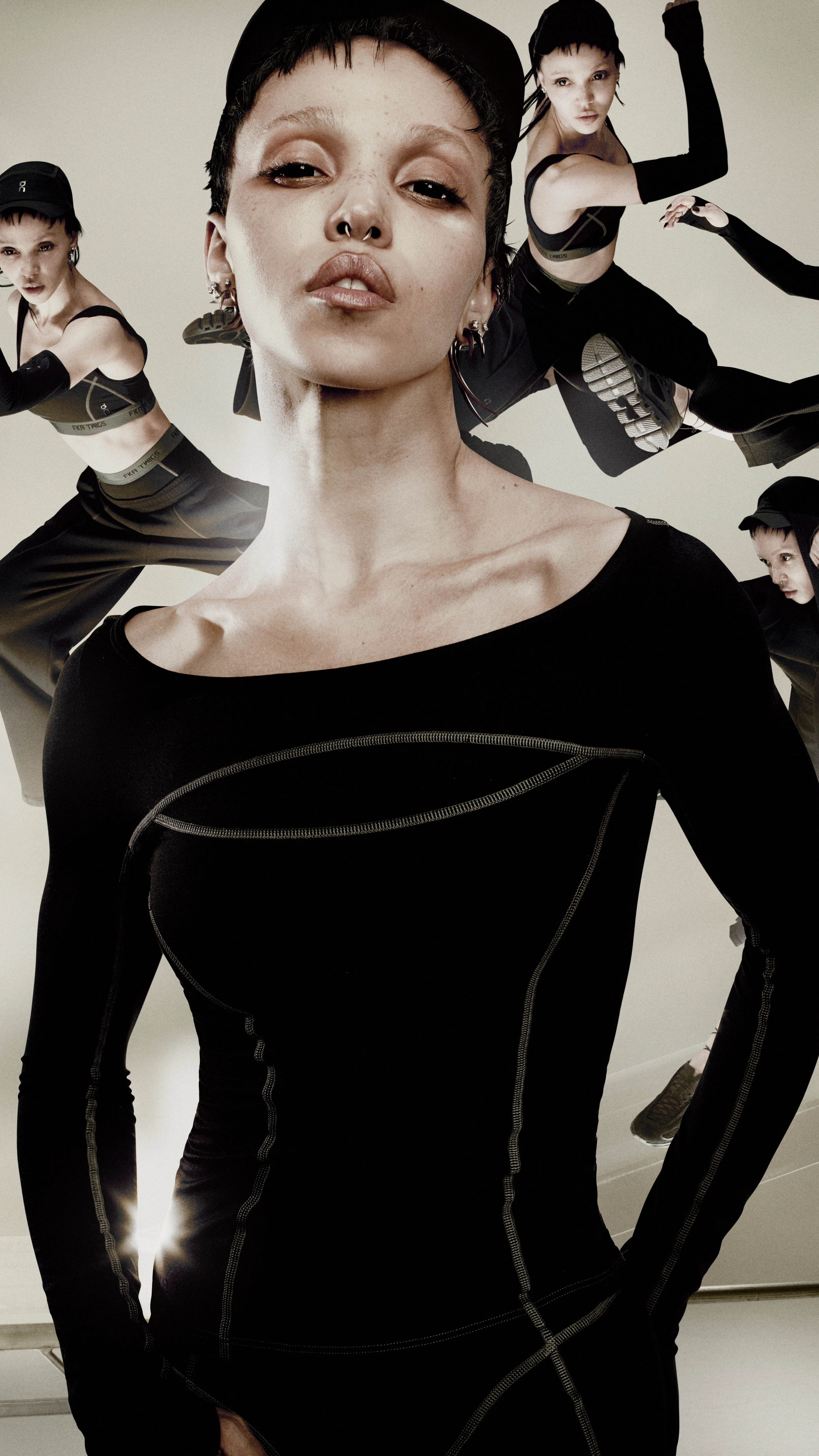 A focused FKA Twigs in a black long-sleeved top from her On capsule collection is surrounded by multiple blurred, moving images of herself against a beige architectural backdrop.