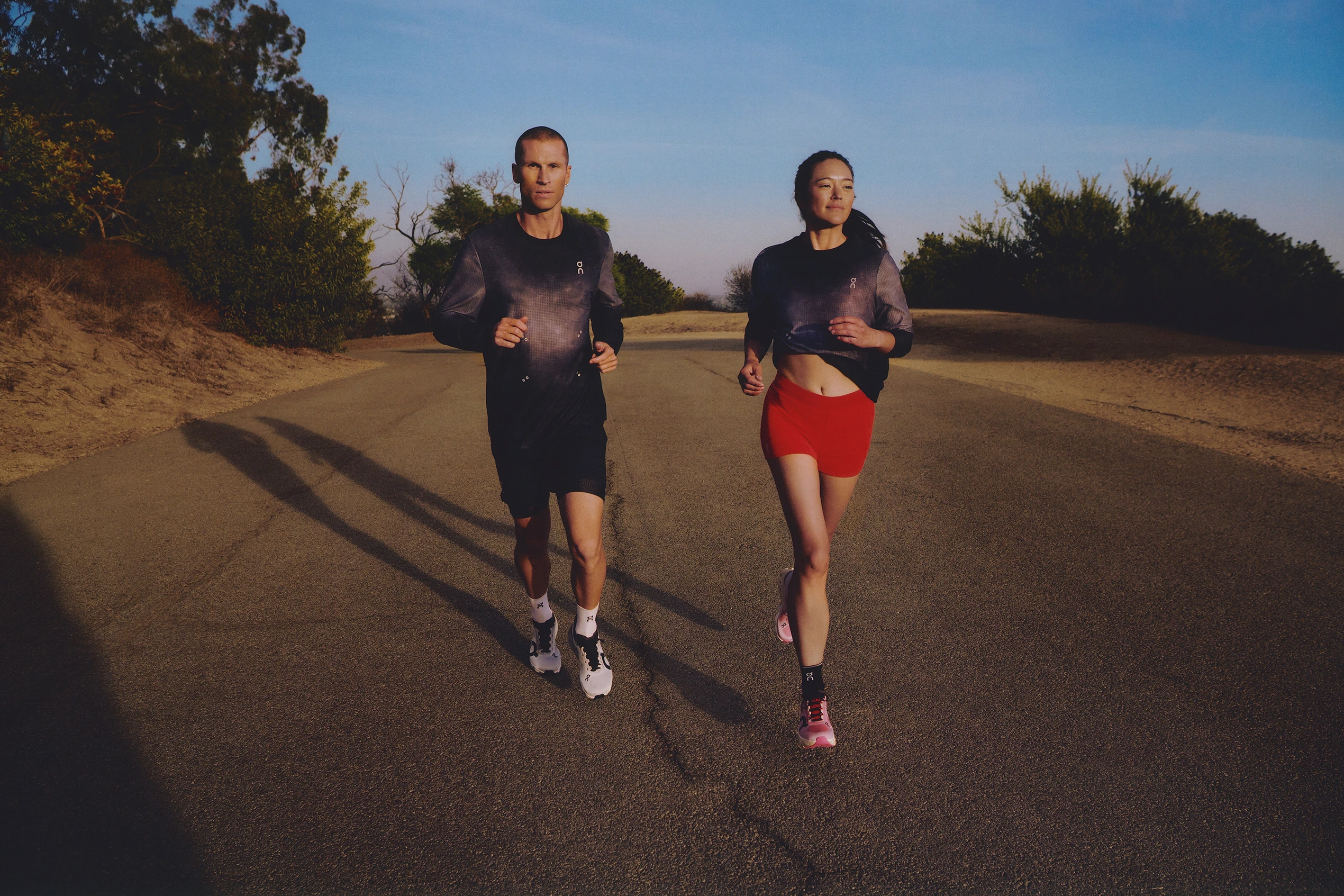 Cloudrunner를 착용하고 다양한 그라데이션을 착용하고 달리는 동안 휴식을 취하는 두 사람의 니다운 샷. 