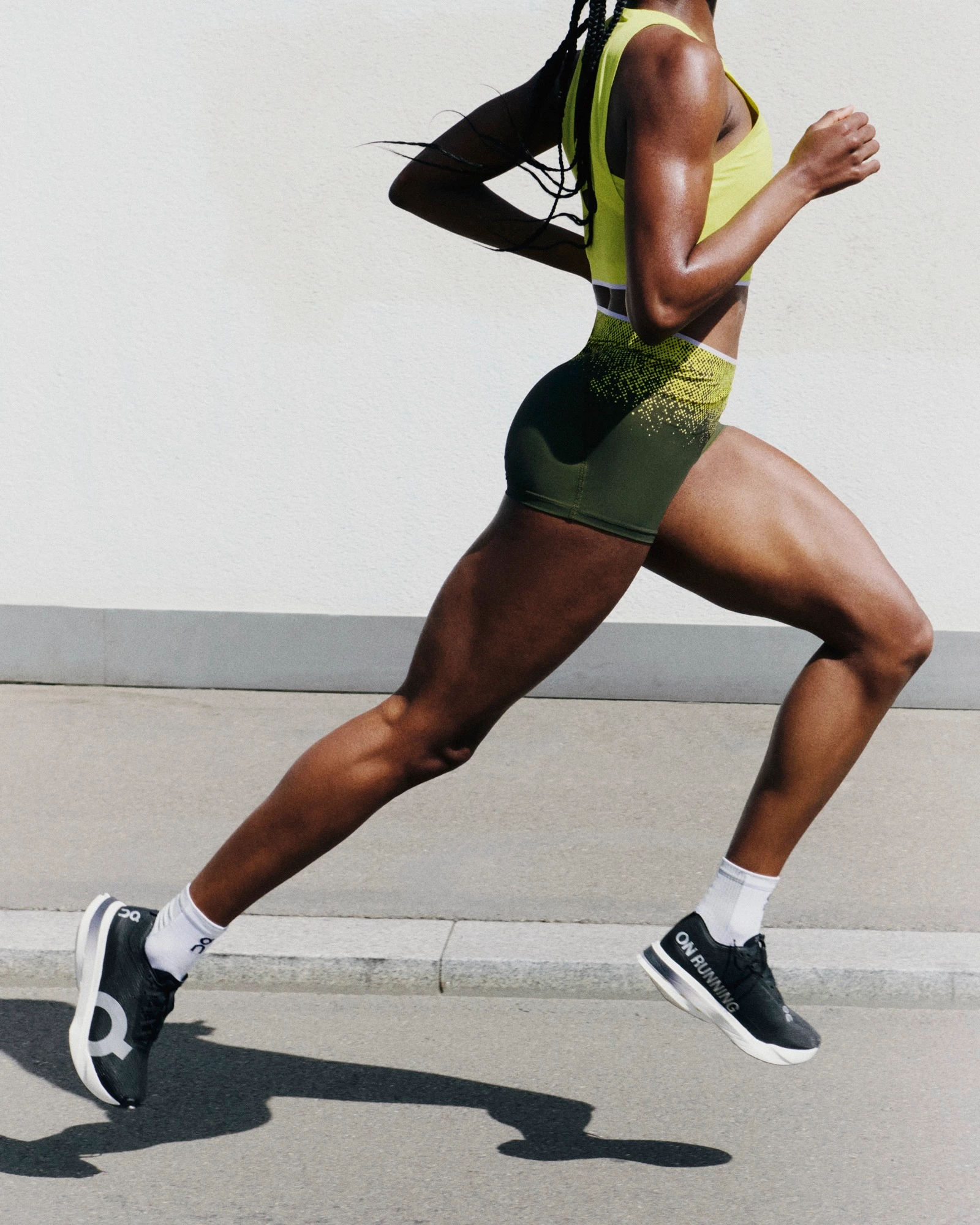 A runner in On gear from the side, mid-stride.